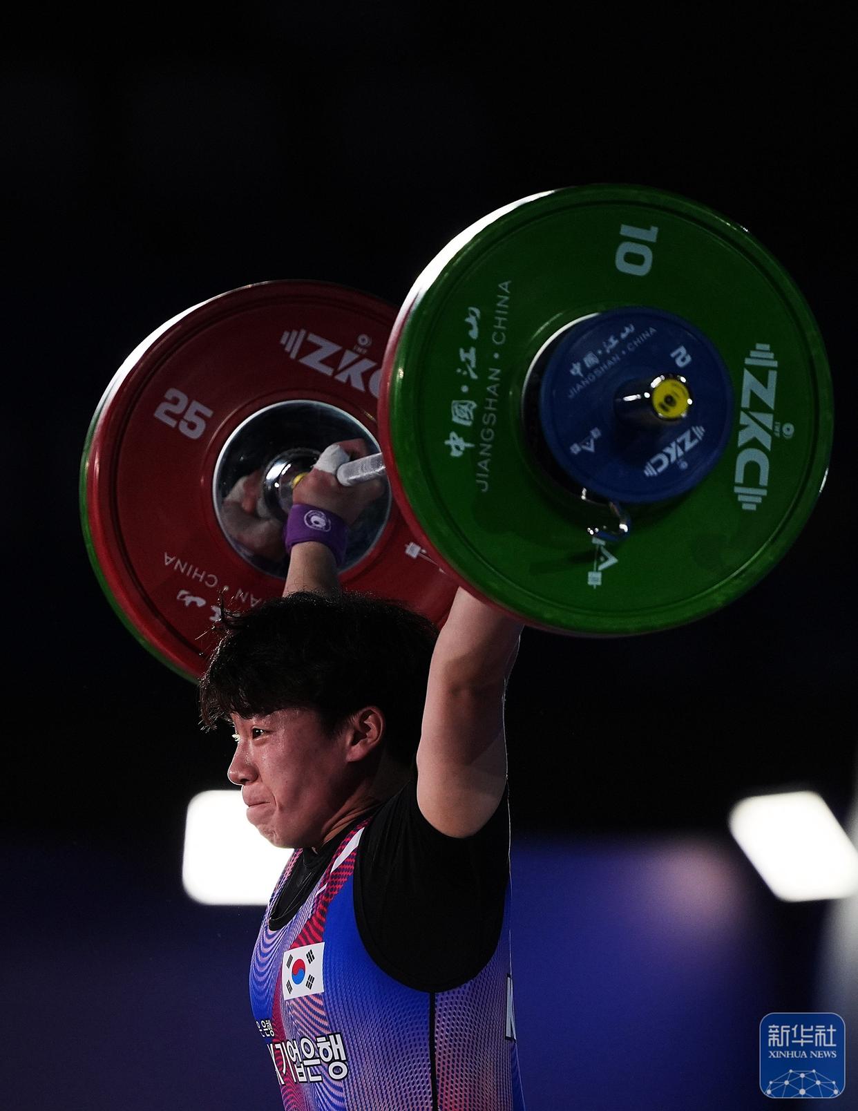 举重比赛进行中，运动员尽力争取领先地位